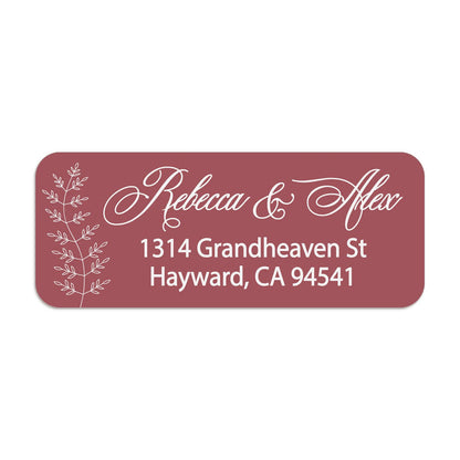 Close-up of burgundy return address sticker with graceful white calligraphy script and botanical branch motif, printed on rectangular label - XOXOKristen