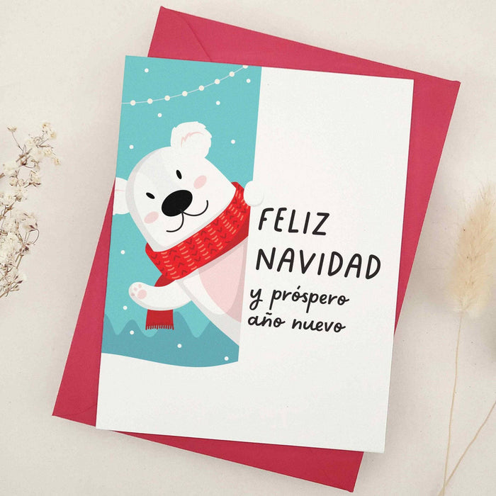 Standing card with cheerful polar bear design, festive snow details, and “Feliz Navidad y Próspero Año Nuevo” message, styled with red envelope — XOXOKristen.