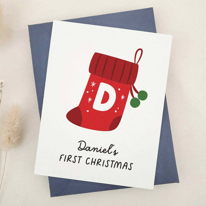 First Christmas card featuring stocking and holly design, styled with navy envelope – XOXOKristen