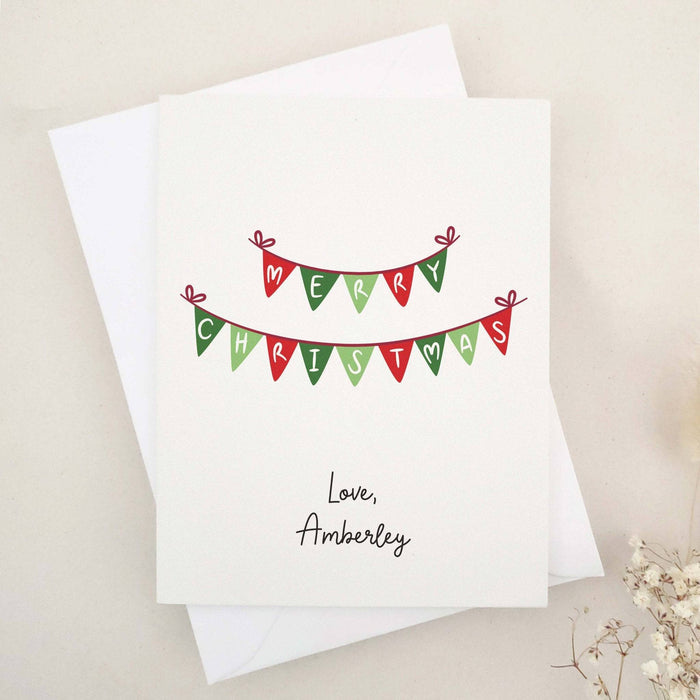 Merry Christmas greeting card with red and green bunting banner design, paired with white envelope – XOXOKristen