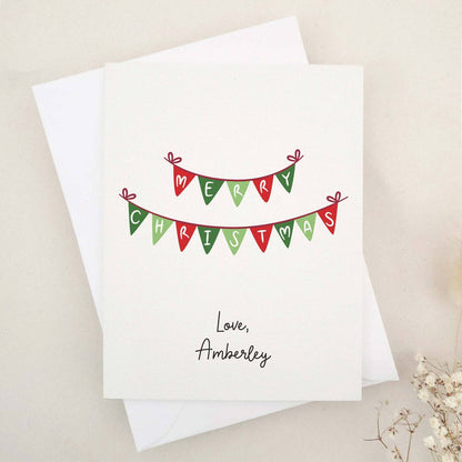Merry Christmas greeting card with red and green bunting banner design, paired with white envelope – XOXOKristen