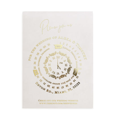 Translucent vellum wedding invitation printed in gold foil with circular clock design and modern script typography, placed in navy envelope – XOXOKristen