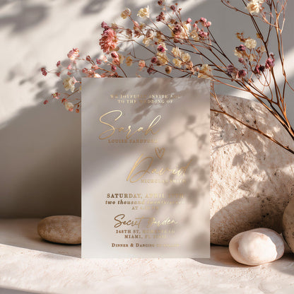 A translucent vellum invitation printed in sleek silver foil, photographed against a neutral background to emphasize its reflective finish. The sophisticated mix of serif and cursive fonts creates a clean modern look, while the frosted texture of the vellum enhances the luxurious metallic detail. A perfect choice for elegant, winter, or modern minimalist weddings. – XOXOKristen